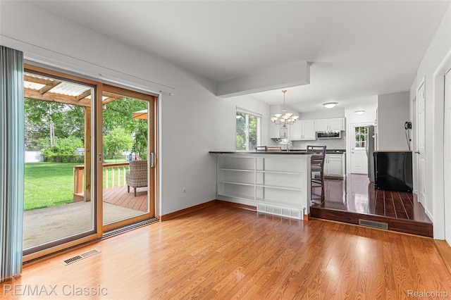 1915 Treadwell St, Westland, MI 48186 - kitchen featuring a chandelier, healthy amount of natural light, dark countertops, and light wood-type flooring