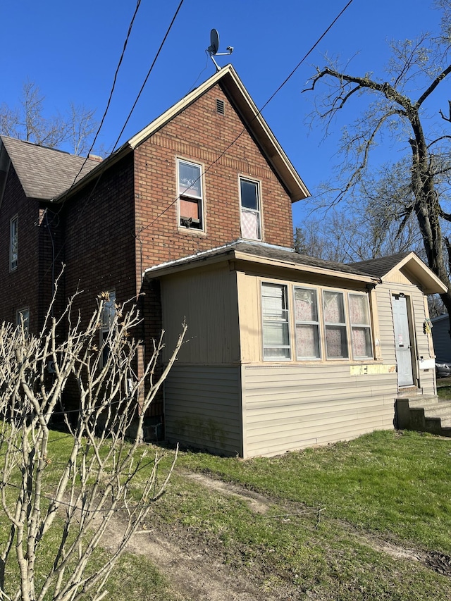 928 Trimble Ave, Kalamazoo, MI 49048 - view of side of property featuring entry steps, brick siding, and a lawn