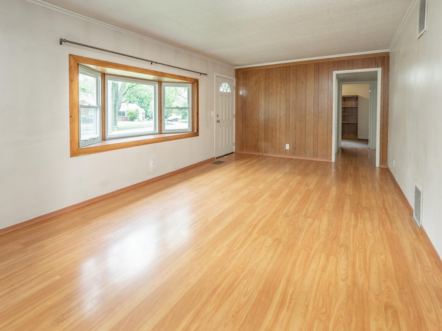 909 Royce Ave, Kalamazoo, MI 49001 - spare room featuring crown molding, light wood finished floors, and wood walls