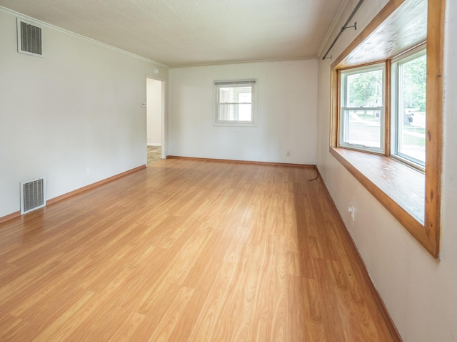 909 Royce Ave, Kalamazoo, MI 49001 - empty room featuring ornamental molding, plenty of natural light, and light wood-style flooring