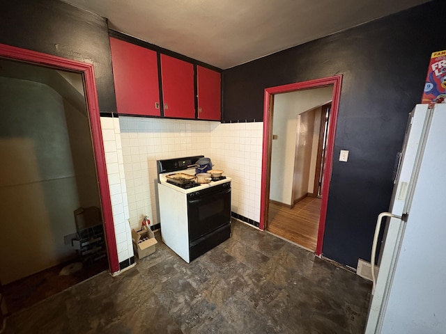 14151 Bringard Dr, Detroit, MI 48205 - kitchen featuring gas range, red cabinetry, freestanding refrigerator, and dark flooring