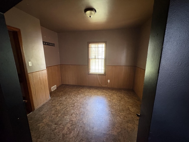 14151 Bringard Dr, Detroit, MI 48205 - spare room featuring wainscoting, wood walls, and tile patterned floors