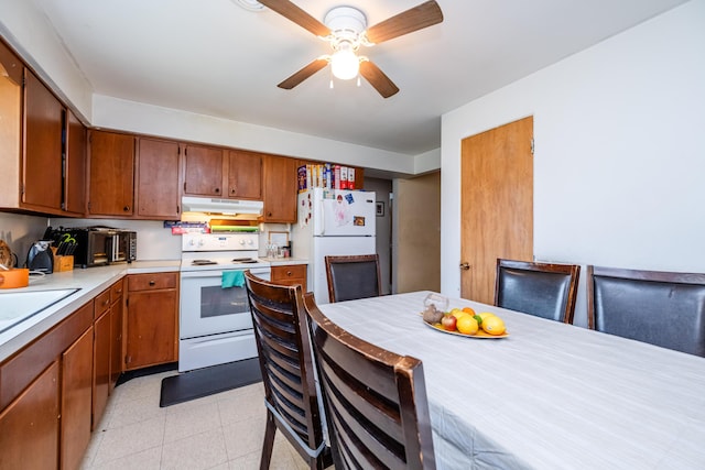 8741 Meadow Ln, Berrien Springs, MI 49103 - kitchen with white appliances, under cabinet range hood, light countertops, and brown cabinetry