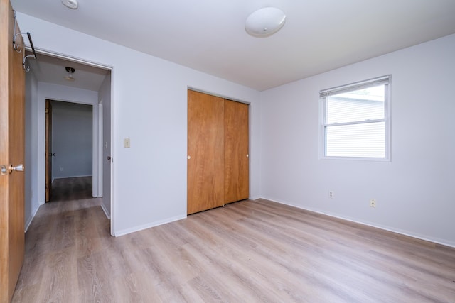 8741 Meadow Ln, Berrien Springs, MI 49103 - unfurnished bedroom with light wood-type flooring and a closet