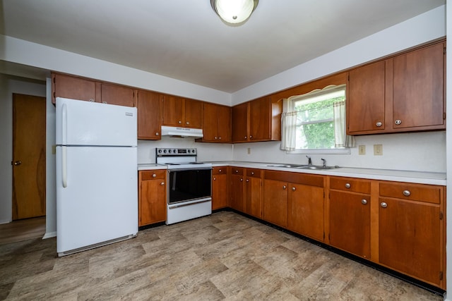 8741 Meadow Ln, Berrien Springs, MI 49103 - kitchen with white appliances, under cabinet range hood, brown cabinetry, and light countertops