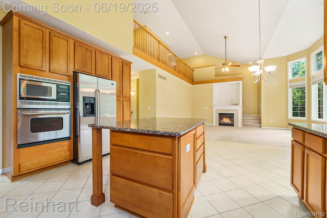 2032 Cameo Ct, Canton, MI 48187 - kitchen with appliances with stainless steel finishes, high vaulted ceiling, a warm lit fireplace, dark stone counters, and light tile patterned flooring
