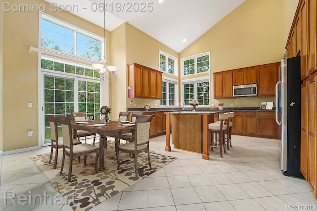 2032 Cameo Ct, Canton, MI 48187 - kitchen with stainless steel appliances, high vaulted ceiling, dark countertops, a center island, and light tile patterned floors