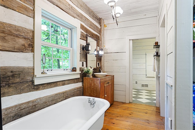 1874 Yeckley Rd, Hastings, MI 49058 - bathroom with wooden walls, a soaking tub, hardwood / wood-style flooring, and vanity