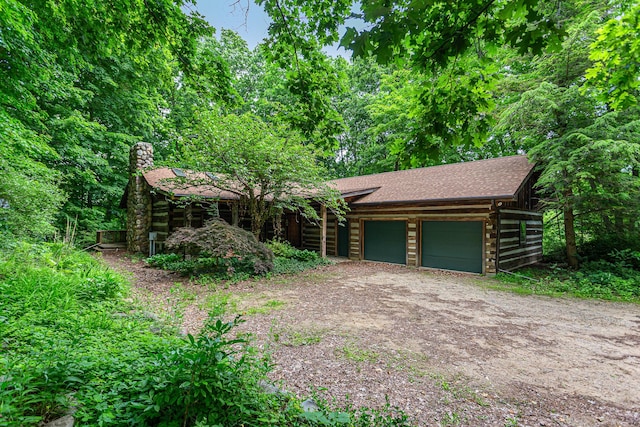 1874 Yeckley Rd, Hastings, MI 49058 - cabin featuring a chimney, an attached garage, driveway, and roof with shingles