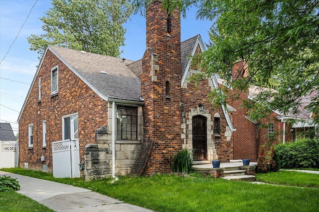 8304 Pinehurst St, Detroit, MI 48204 - tudor home with a shingled roof, a chimney, and brick siding