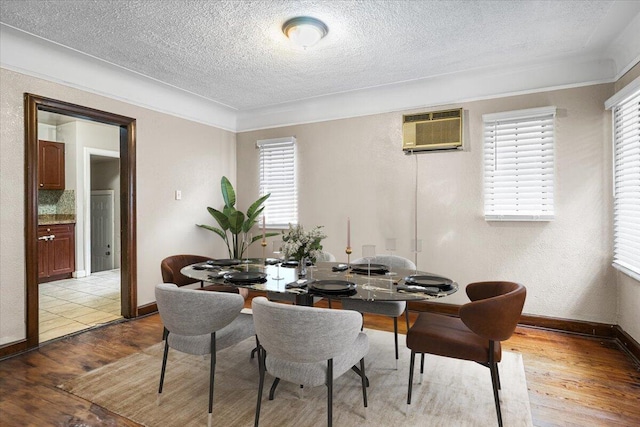 8304 Pinehurst St, Detroit, MI 48204 - dining area with light wood-style floors, a textured ceiling, a wall mounted air conditioner, and plenty of natural light