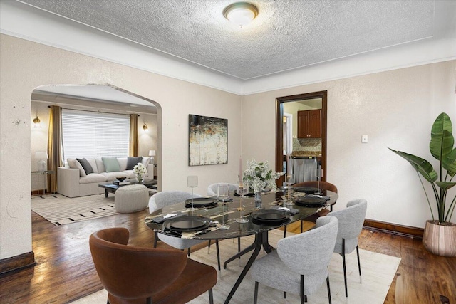8304 Pinehurst St, Detroit, MI 48204 - dining room with arched walkways, a textured ceiling, and wood finished floors