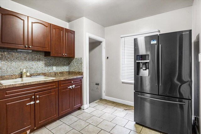 8304 Pinehurst St, Detroit, MI 48204 - kitchen with stainless steel fridge, light tile patterned flooring, and decorative backsplash