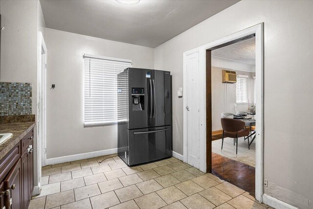 8304 Pinehurst St, Detroit, MI 48204 - kitchen featuring black fridge with ice dispenser, a wall mounted AC, dark brown cabinetry, and light tile patterned floors