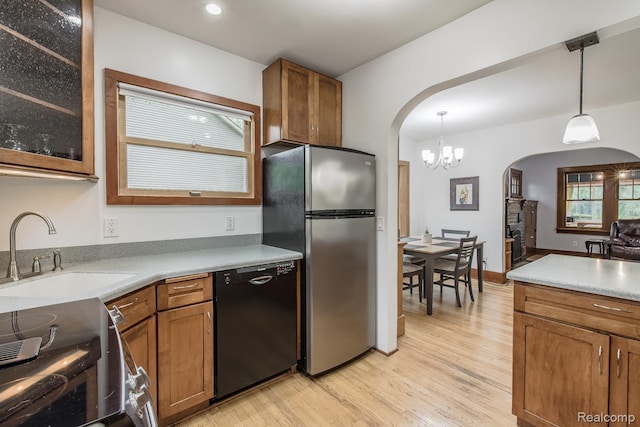 284 W Clarkston Rd, Lake Orion, MI 48362 - kitchen featuring arched walkways, black dishwasher, freestanding refrigerator, and light wood finished floors