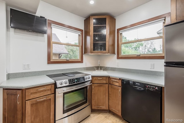 284 W Clarkston Rd, Lake Orion, MI 48362 - kitchen featuring stainless steel appliances, healthy amount of natural light, glass insert cabinets, and brown cabinets