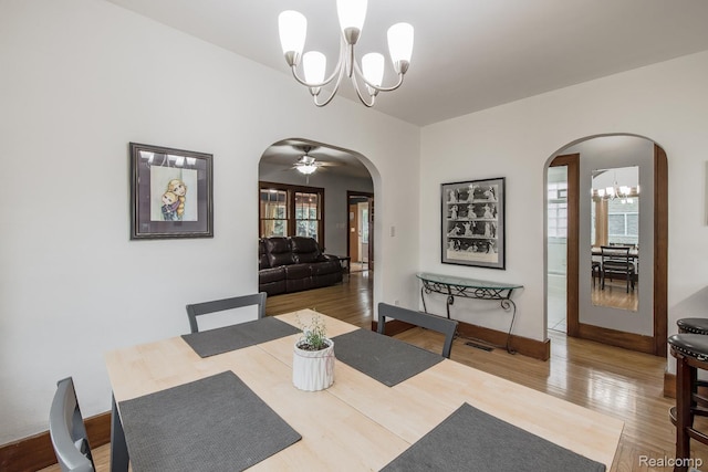 284 W Clarkston Rd, Lake Orion, MI 48362 - dining room with arched walkways, a chandelier, and wood finished floors