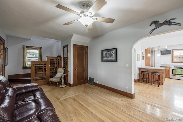 284 W Clarkston Rd, Lake Orion, MI 48362 - living area featuring ceiling fan, light wood-style floors, arched walkways, and healthy amount of natural light