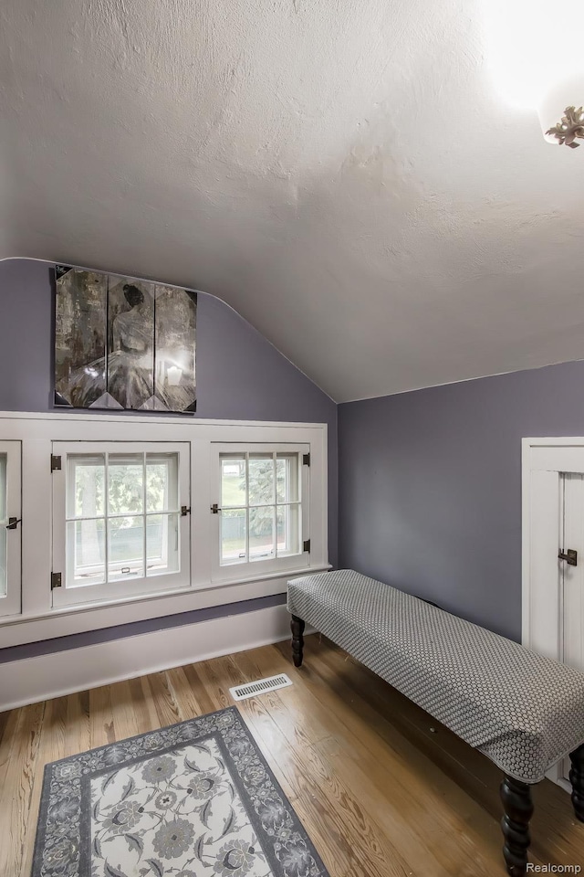 284 W Clarkston Rd, Lake Orion, MI 48362 - unfurnished bedroom featuring lofted ceiling, wood finished floors, and a textured ceiling