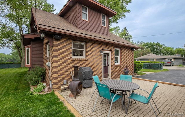 284 W Clarkston Rd, Lake Orion, MI 48362 - back of property with brick siding, roof with shingles, and a patio area