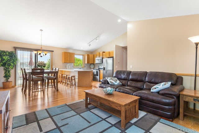 2973 Riley Ridge Rd, Holland, MI 49424 - living area with light wood-style floors, vaulted ceiling, and a chandelier