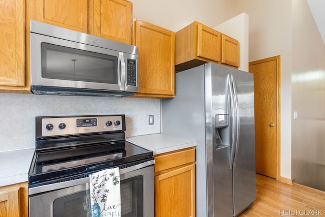 2973 Riley Ridge Rd, Holland, MI 49424 - kitchen featuring appliances with stainless steel finishes, light countertops, tasteful backsplash, and light wood-type flooring