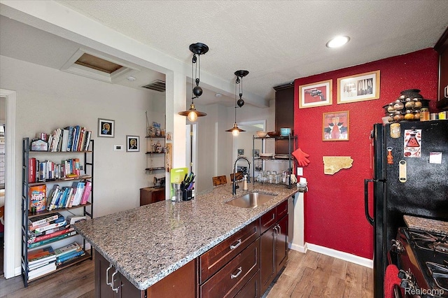 1769 W Warren Ave, Detroit, MI 48208 - kitchen featuring black appliances, wood finished floors, light stone countertops, hanging light fixtures, and recessed lighting
