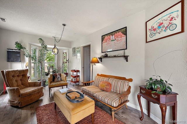 1769 W Warren Ave, Detroit, MI 48208 - living area with wood finished floors, a textured ceiling, and a textured wall