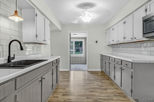 338 Cherry St, Blissfield, MI 49228 - kitchen with stainless steel microwave, tasteful backsplash, light countertops, and dark wood finished floors
