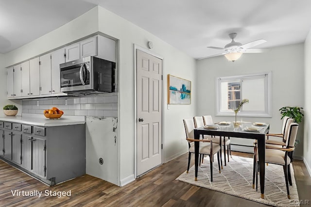 338 Cherry St, Blissfield, MI 49228 - kitchen with stainless steel microwave, decorative backsplash, ceiling fan, dark wood-style flooring, and gray cabinets