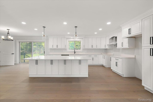 56350 Willow Creek Blvd, Utica, MI 48316 - kitchen with wall chimney range hood, a kitchen island, healthy amount of natural light, white cabinetry, and recessed lighting