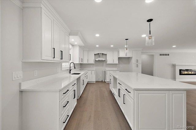 56350 Willow Creek Blvd, Utica, MI 48316 - kitchen featuring wall chimney range hood, recessed lighting, a kitchen island, white cabinetry, and wood finished floors
