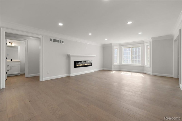 56350 Willow Creek Blvd, Utica, MI 48316 - unfurnished living room with ornamental molding, light wood-style flooring, a glass covered fireplace, and recessed lighting