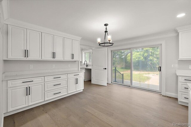 56350 Willow Creek Blvd, Utica, MI 48316 - kitchen featuring a chandelier, white cabinetry, light countertops, light wood-type flooring, and ornamental molding
