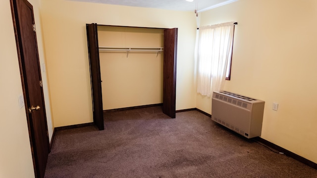 2250 Pray Rd, Charlotte, MI 48813 - unfurnished bedroom featuring dark carpet, heating unit, and a closet