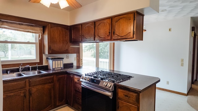 2250 Pray Rd, Charlotte, MI 48813 - kitchen with stainless steel gas range, dark countertops, a peninsula, light floors, and ceiling fan