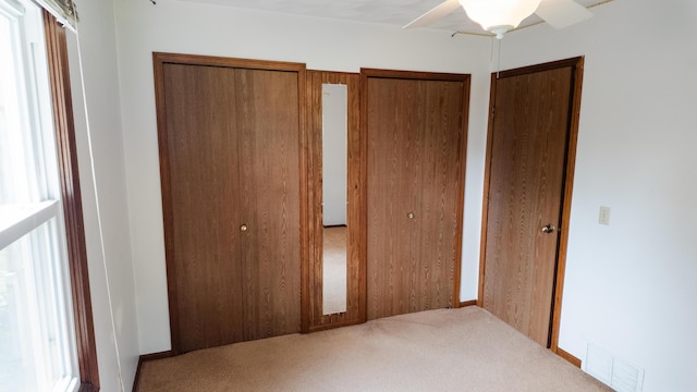 2250 Pray Rd, Charlotte, MI 48813 - unfurnished bedroom with carpet floors, two closets, multiple windows, and ceiling fan