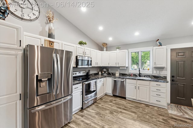 3328 S Vassar Rd, Burton, MI 48519 - kitchen with stainless steel appliances, white cabinetry, recessed lighting, lofted ceiling, and light wood-style floors