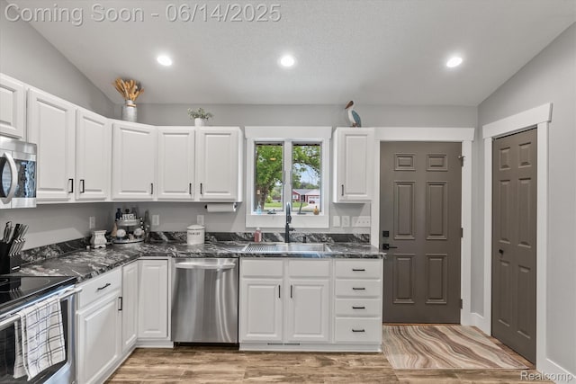 3328 S Vassar Rd, Burton, MI 48519 - kitchen featuring appliances with stainless steel finishes, recessed lighting, white cabinets, lofted ceiling, and dark stone counters