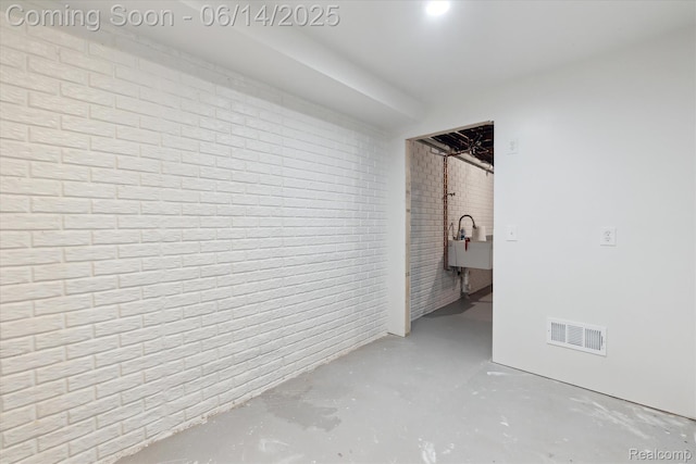 3328 S Vassar Rd, Burton, MI 48519 - empty room with brick wall and concrete flooring