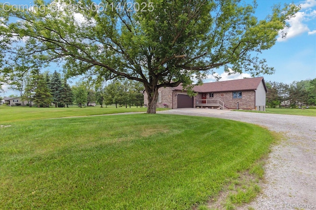 3328 S Vassar Rd, Burton, MI 48519 - view of green lawn featuring gravel driveway and an attached garage