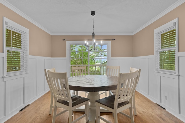 8475 Homerich Ave SW, Byron Center, MI 49315 - dining space with a decorative wall, a chandelier, light wood-type flooring, a wainscoted wall, and ornamental molding