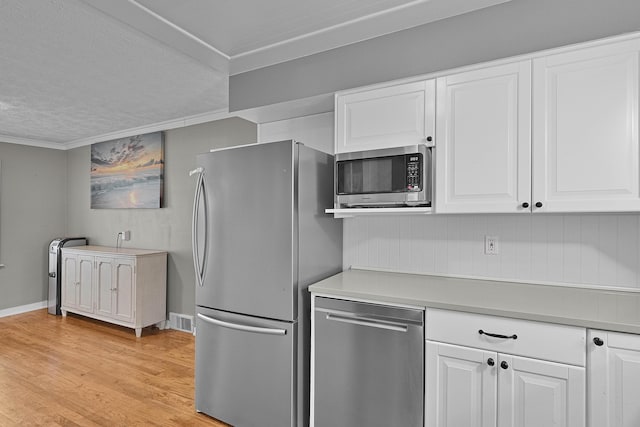 8475 Homerich Ave SW, Byron Center, MI 49315 - kitchen featuring stainless steel appliances, white cabinets, crown molding, light wood-style flooring, and light countertops