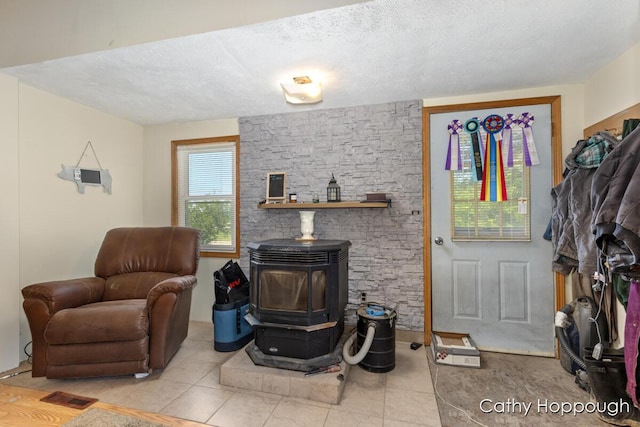 3119 S Hillman Rd, Sidney, MI 48885 - living room featuring a wood stove, tile patterned floors, and a textured ceiling