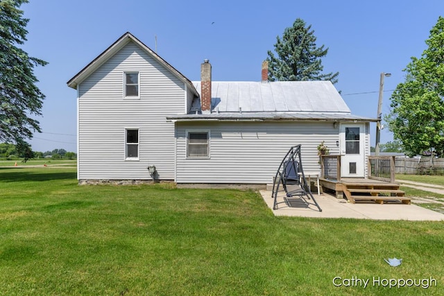 3119 S Hillman Rd, Sidney, MI 48885 - back of property with a patio, a chimney, a lawn, and a deck