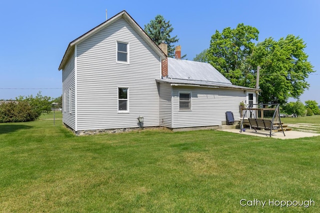 3119 S Hillman Rd, Sidney, MI 48885 - back of property featuring a yard, a chimney, a patio, and a deck