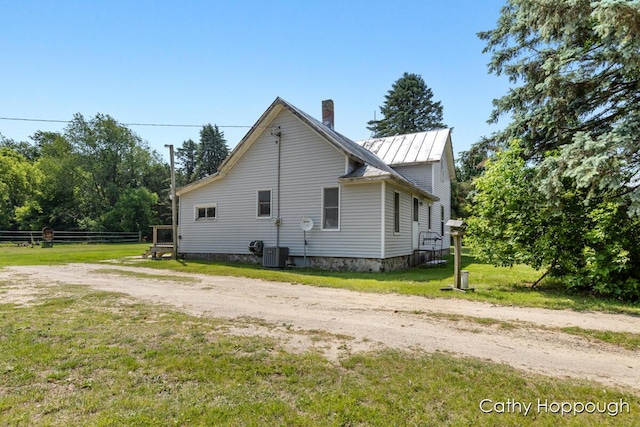 3119 S Hillman Rd, Sidney, MI 48885 - view of side of home with a chimney, a metal roof, and a standing seam roof
