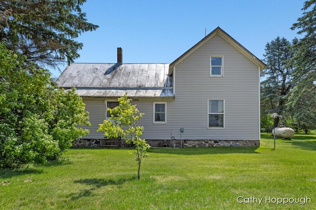 3119 S Hillman Rd, Sidney, MI 48885 - rear view of house featuring a yard, a metal roof, a chimney, and a standing seam roof