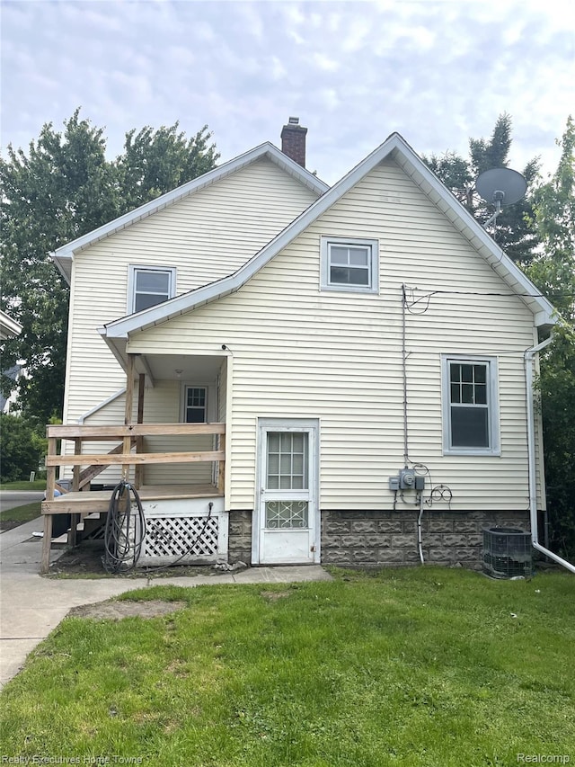 1209 Miller St, Port Huron, MI 48060 - rear view of property featuring a chimney, a lawn, and a deck