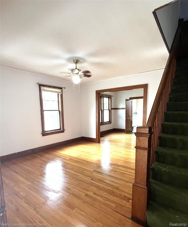 1209 Miller St, Port Huron, MI 48060 - spare room featuring stairway, plenty of natural light, ceiling fan, and light wood-type flooring